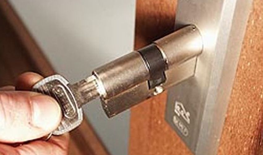 Monteur sleutelt aan een deurslot bij een woning in Laren Monteur sleutelt aan een deurslot bij een woning in Laren